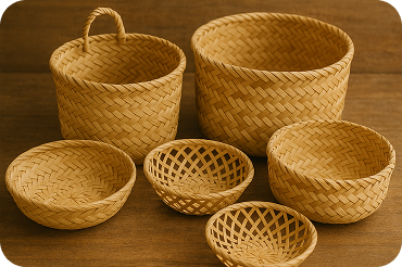 Conjunto de cestos e tigelas de palha trançada artesanalmente em diferentes tamanhos sobre uma superfície de madeira.